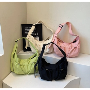 Détail de quatre sacs hobo en nylon léger de différentes couleurs sur un présentoir
