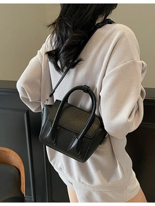 Classic black pebbled leather handbag with top handles and adjustable strap for women