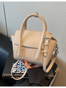 Chic beige lychee textured leather handbag with crossbody strap and metal buckle