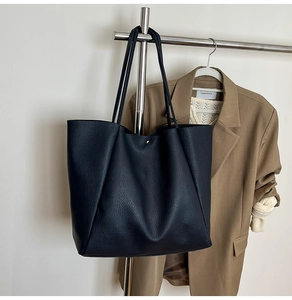 Detail der schwarzen Leder-Tote-Bag mit goldener Magnetschließe am Kleiderständer