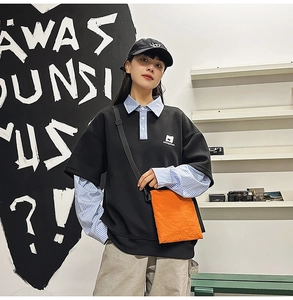 Close-up of the stylish orange nylon crossbody bag paired with a streetwear outfit