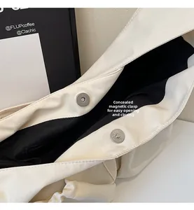 Détail du fermoir magnétique invisible sur le sac à bandoulière en nylon beige