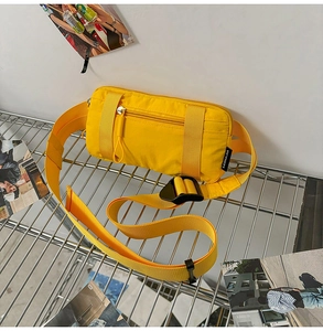 Detail of bright yellow nylon sports waist bag with zipper pocket and adjustable strap