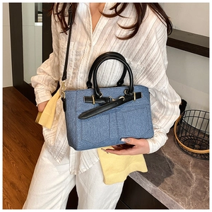 Blue denim texture bucket bag shown with black straps and adjustable shoulder strap on model