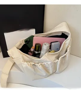 Vue de dessus montrant la grande capacité du sac bandoulière beige en nylon souple