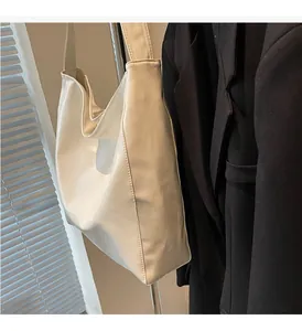Detail view of the sleek cream tote bag with structured base and premium stitching
