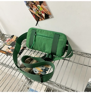 Detailed macro view of grass green nylon sports waist bag with black buckle on metal rack