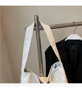 Detail of a minimalist cream tote bag with soft wide shoulder straps and leather texture