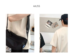 Detail of adjustable strap and blue woven tag on minimalist black crossbody messenger bag
