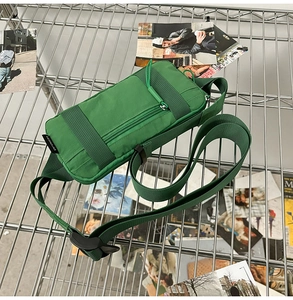 Detail of green nylon crossbody bag with adjustable strap and functional zipper pockets