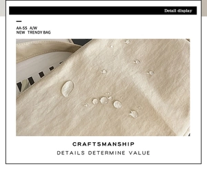 Detail of water-resistant fabric with clear droplets on a beige crossbody shoulder bag