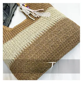 Detailed view of woven straw tote bag with decorative lace ribbon and colorful beads