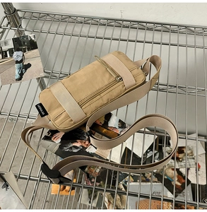 Detail of khaki nylon tactical waist bag with plastic buckle on metal mesh rack