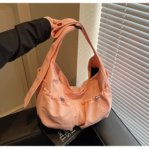 Détail macro du sac hobo en nylon pêche avec poches à cordon et large bandoulière