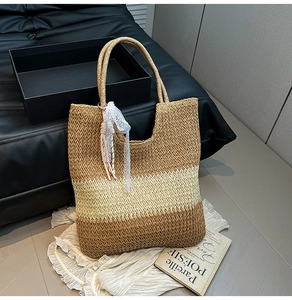 Detail of three-tone straw woven tote bag with white lace ribbon decoration on handle