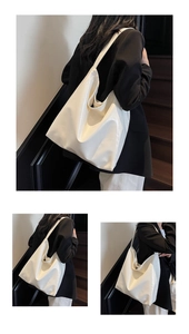 Detailed view of a white large PU leather tote bag worn by a model in a black suit