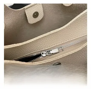 Detailed macro view of high-quality metal zipper and lychee grain leather on large bucket bag