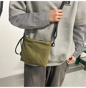 Detail of army green nylon crossbody bag with adjustable wide strap and zipper closure