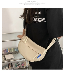 Back view of a beige half-moon crossbody bag made of durable canvas with wide strap
