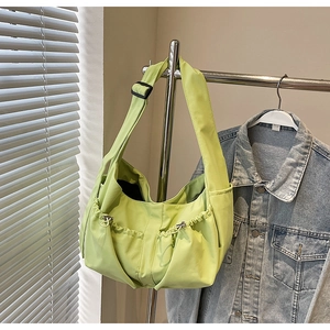 Détail du sac hobo en nylon vert clair avec large bandoulière et poches à cordon coulissant
