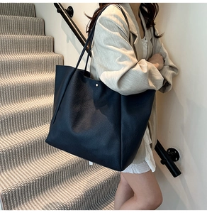 Detailansicht der schwarzen Tote-Bag aus genarbtem Leder mit edler Metall-Niete