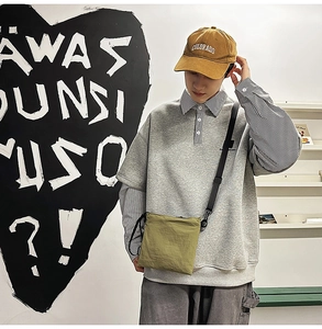 Army green nylon envelope bag styled with Japanese streetwear outfit on model