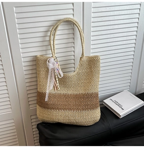 Detail of bohemian straw tote bag featuring bicolor woven texture and white lace ribbon