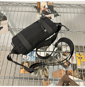 Detail of durable black nylon sports waist bag featuring adjustable strap and side brand tag