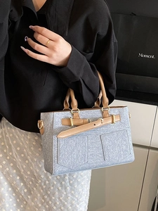 Blue denim fabric bucket bag with brown leather trim and golden metal hardware details