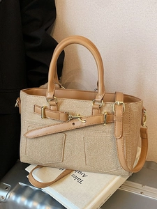 Khaki woven bucket handbag with camel leather handles and gold buckle accent on book