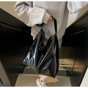 Chic black glossy tote bag styled on model showcasing its large capacity and sleek design