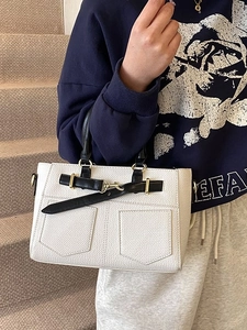 Elegant white bucket bag with black contrast trim and gold hardware in hand-held style