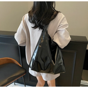 Rear view of a model wearing the black glossy hobo tote bag for daily casual outfit
