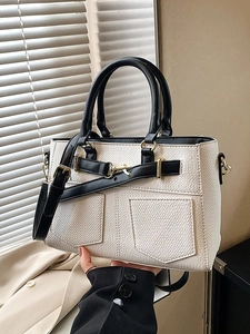 Chic cream bucket bag with black trim and gold hardware for crossbody or handbag use