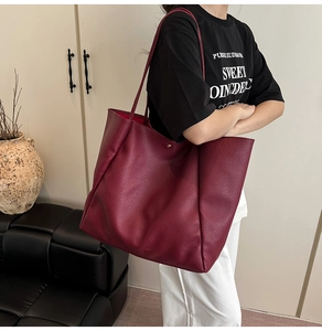 Nahaufnahme der burgunderroten Tasche mit Lychee-Narbenleder an der Schulter