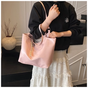 Pink glossy tote bag with embossed lettering and silk scarf detail on shoulder