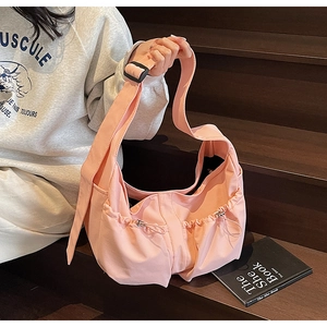 Détail du sac bandoulière rose en nylon avec bandoulière réglable et poches à cordon