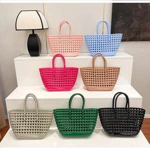 Detailed view of colorful hollow woven silicone tote bags on a modern display stand