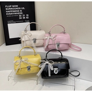 Detail showing colorful PU leather square handbags with elegant pearl lace bows