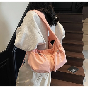 Détail du sac bandoulière en nylon plissé rose avec cordon de serrage et large bandoulière