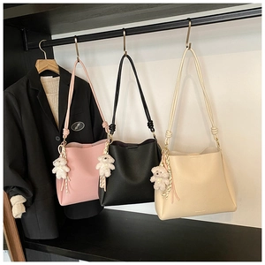 Trois sacs seaux en cuir rose, noir et crème avec breloques d'ours en peluche et glands