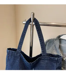 Detail der robusten Denim-Schultergurte einer blauen Vintage-Tasche am Ständer