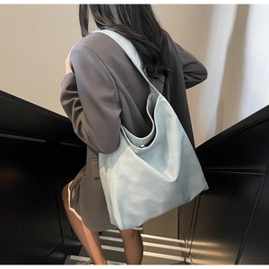 Detailed view of light blue large capacity tote bag with soft leather texture and magnetic buckle