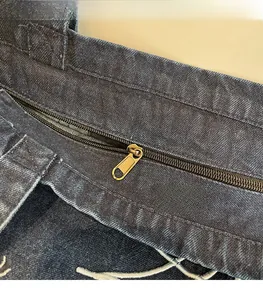 Detail einer Vintage-Jeanstasche mit Bronze-Reißverschluss und doppelten Nähten