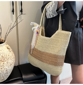 Detail of straw woven tote with lace bow ornament and beads on the handle side