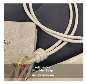Détail de la bandoulière réglable en cuir avec anneau doré sur un sac beige