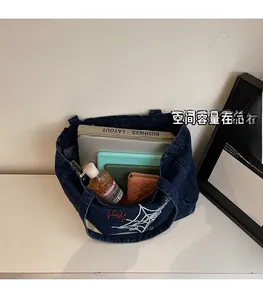 Makroansicht der Denim-Tasche mit großem Innenraum für Laptop und tägliche Gegenstände