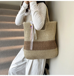 Detail of woven straw tote bag featuring herringbone pattern and colorful bead ribbon charms