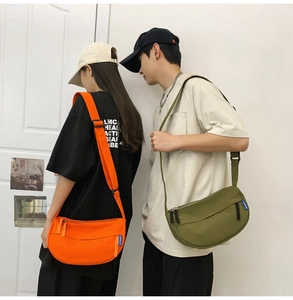 Detail view of nylon crescent crossbody bags in orange and olive green on models