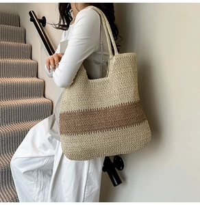Detail of handwoven straw tote bag featuring beige and brown wavy textured pattern